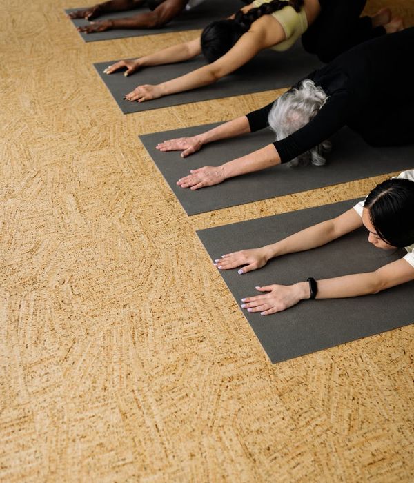 Person demonstrating a strengthening yoga pose on a saffron background.